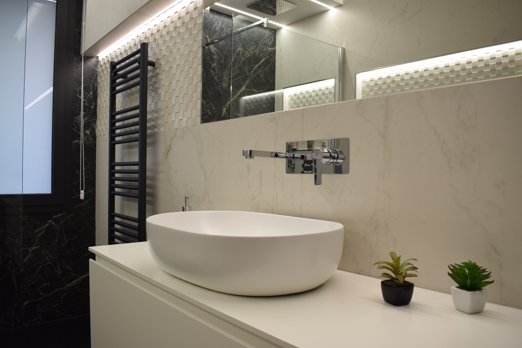 Bagno con rivestimenti in marmo scuro e lavabo da appoggio