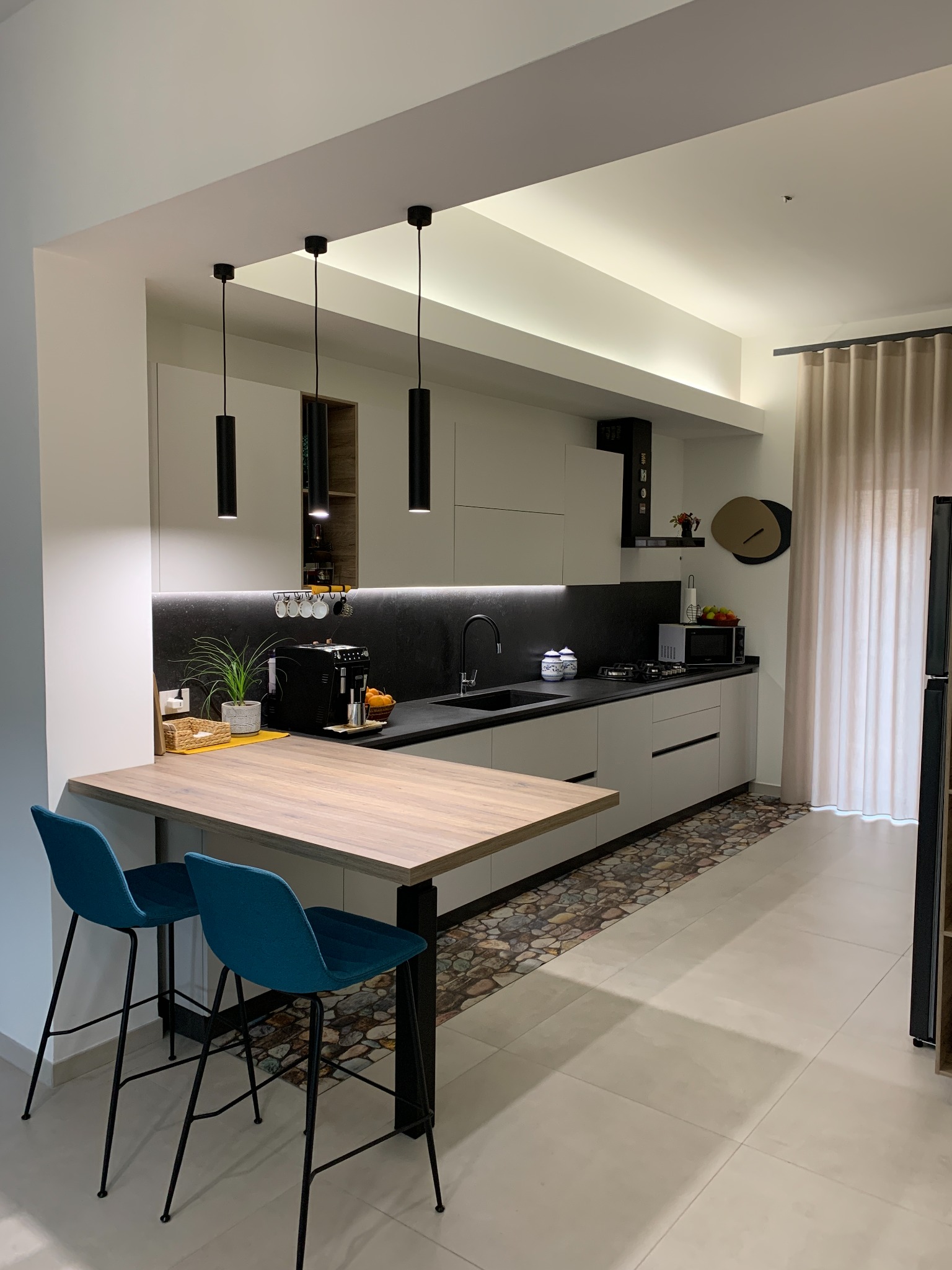 Cucina bianca con piano nero e tavolo in legno