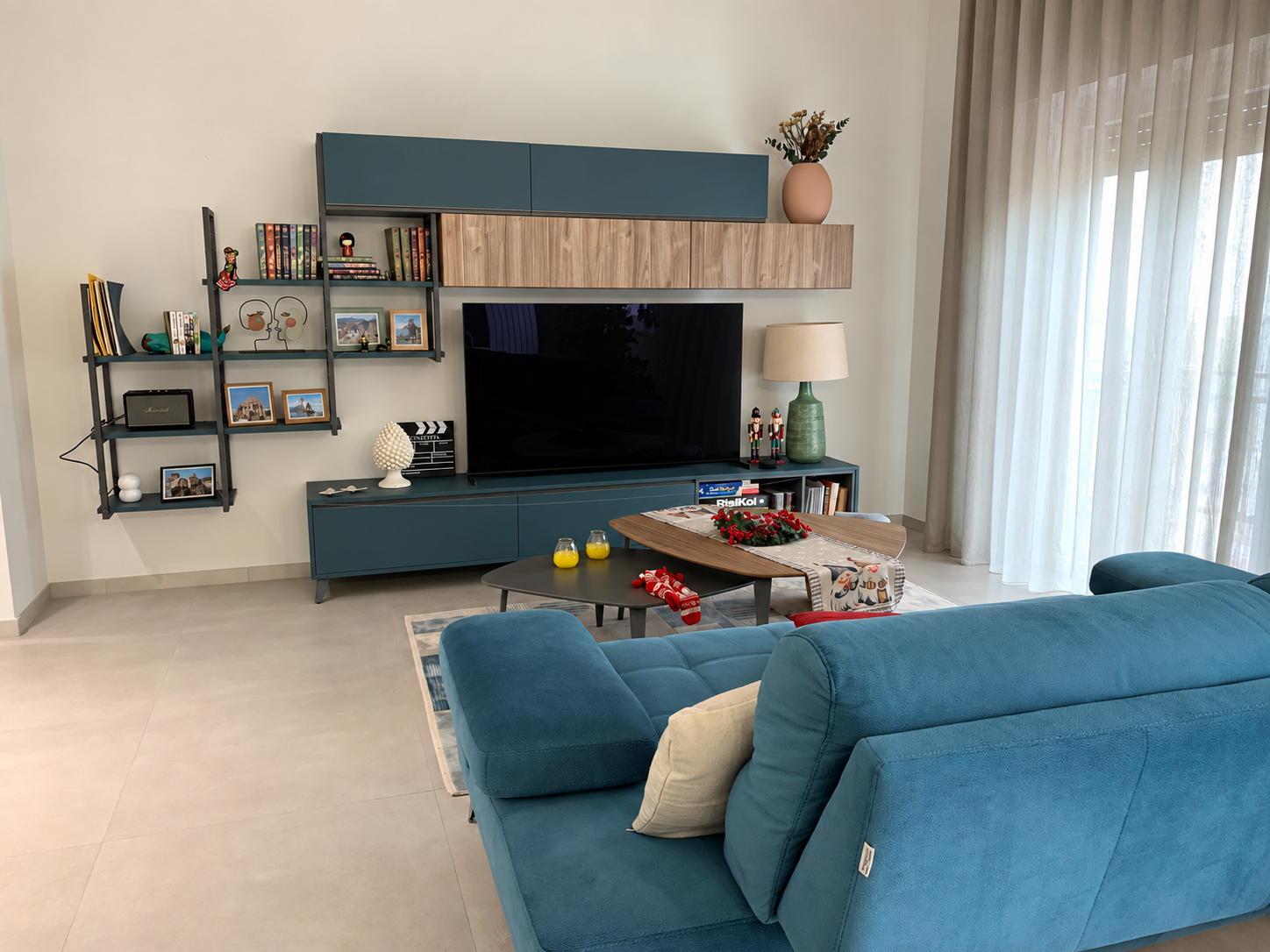 Soggiorno con divano blu, libreria e mobile TV